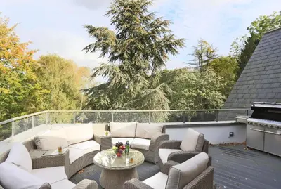 a patio with couches and a table on a roof at 6 Bed in Lavenham oc-stofa in Lavenham
