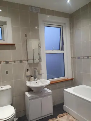 a bathroom with a sink and a toilet and a window at The Westcliff Room in Southend-on-Sea