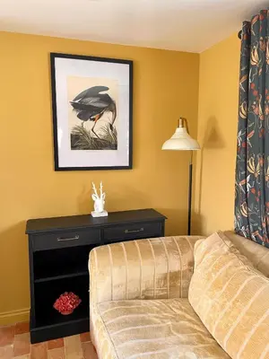 a living room with a couch and a lamp at The Hayloft in Gestingthorpe