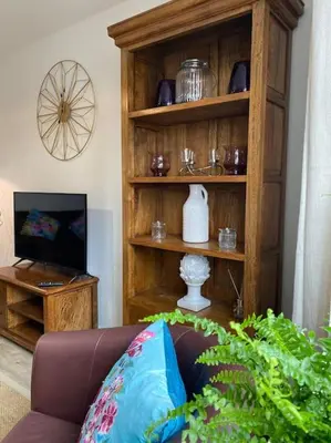 a living room with a brown couch and a television at Comfortable new home in Isleham in Ely
