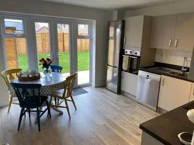a kitchen and dining room with a table and chairs at Comfortable new home in Isleham in Ely