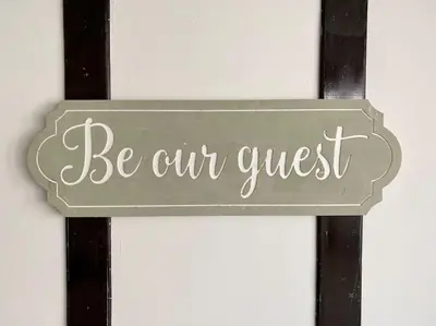 a sign that says be our guest on a wall at Charming Seaside Cottage in Leigh-on-Sea in Southend-on-Sea