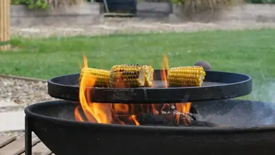 a bunch of corn on a grill with flames at The Firs in Cratfield