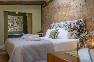 two beds with towels on them in a room at The Firs in Cratfield