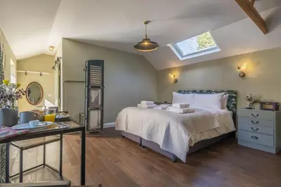 a bedroom with a bed and a dresser and a window at The Firs in Cratfield