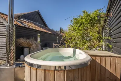 a bath tub sitting on a wooden fence at The Firs in Cratfield