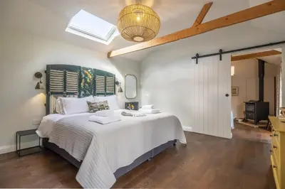 a bedroom with a large bed with white sheets at The Firs in Cratfield
