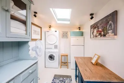 a small kitchen with a washer and dryer in it at Lantern Cottage, Debenham in Stowmarket