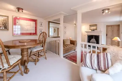a living room with a table and a fireplace at Lantern Cottage, Debenham in Stowmarket