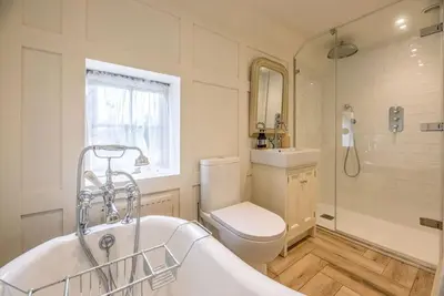 a bathroom with a tub and a toilet and a sink at Lantern Cottage, Debenham in Stowmarket