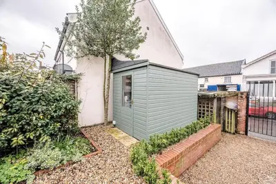 a small green shed in front of a house at Lantern Cottage, Debenham in Stowmarket