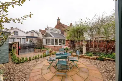 a patio with a table and chairs in a yard at Lantern Cottage, Debenham in Stowmarket