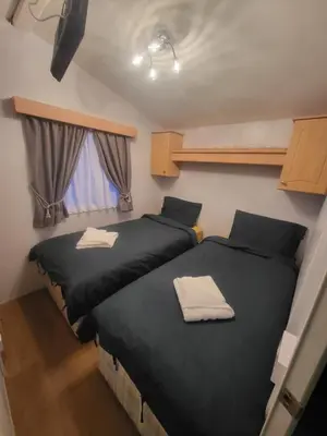 two beds in a small room with black sheets at Vacation Escape - Valley Farm -Clacton-on-sea - Holiday Park in Clacton-on-Sea